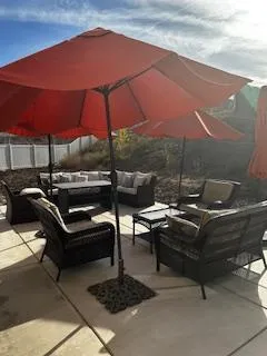 Outdoor backyard patio with shaded seating and umbrellas — a quiet place for residents to rest, reflect, and connect.