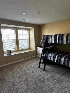 Comfortable resident bedroom with a bunk bed and a bright bay window.
