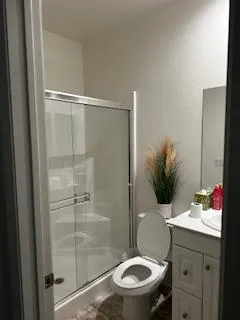 Clean, updated bathroom with a glass-enclosed walk-in shower.