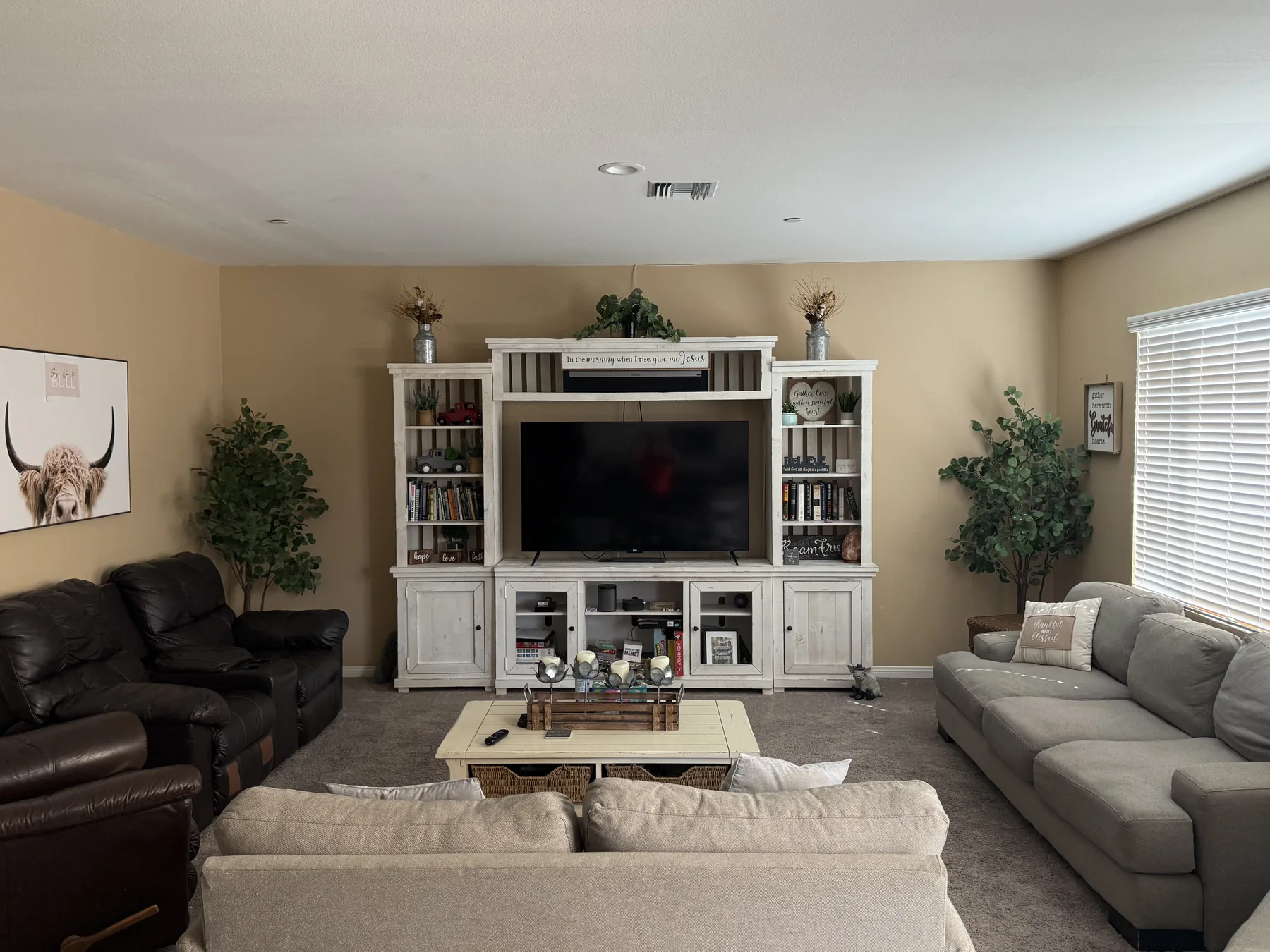 Spacious, welcoming living room at Grace Refuge Recovery with comfortable couches, a large TV, bookshelves, and faith-filled decor where residents gather as a family.